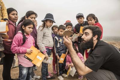A Cerro de oro archaeologist showing a fragment of pottery to children at Watch Day 2018.