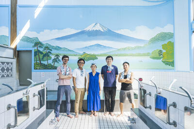 Sam (far left) with other S&N Directors in front of the traditional Mt. Fuji bathhouse mural. Photo credit: S&N. 
