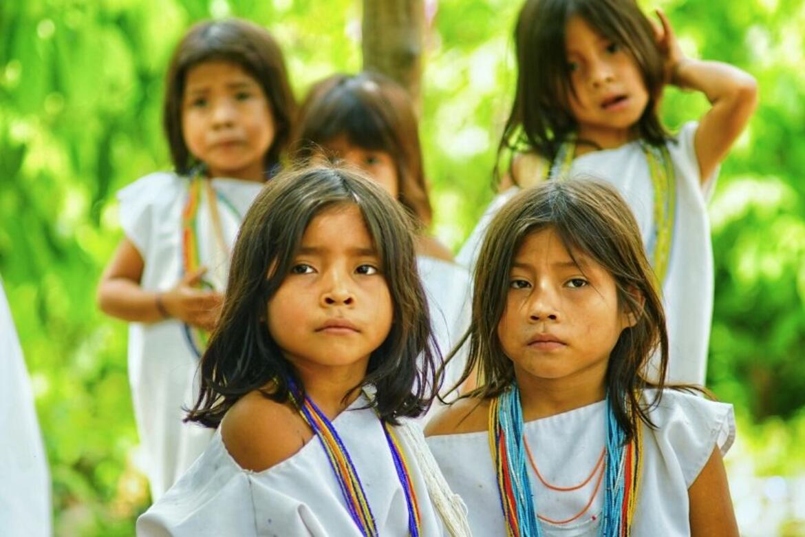 Group of children in white clothing with colorful bead necklaces