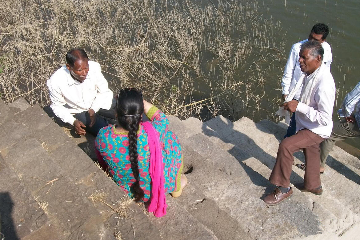 Local community members explain the water system at Daulatabad Fort.