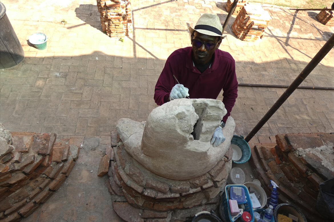 Ousmane Kounta working on a Buddha statue
