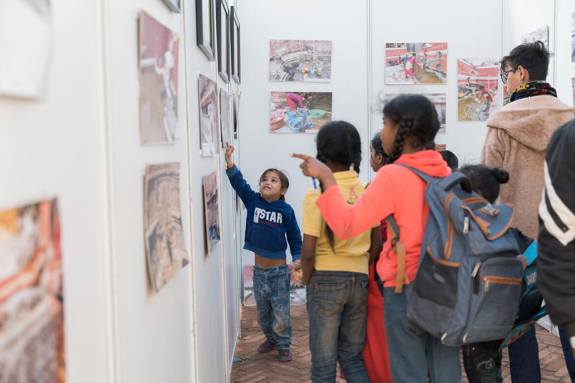 Visitors pointing at photos in an exhibition devoted to the hitis of Kathmandu Valley