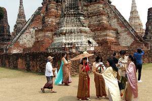 Fans of the show Love Destiny pose for photos in costume at Wat Chaiwatthanaram.