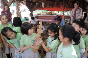 School children with a woodcarving example at Shwe-nandaw Kyaung, 2019