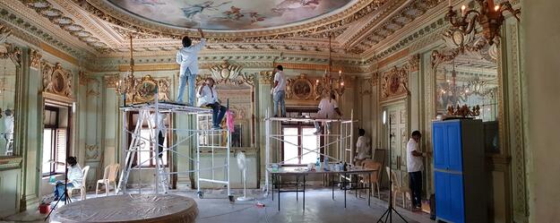 Group of people on scaffolding inside the palace doing conservation work