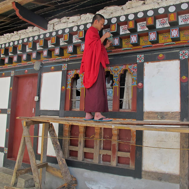 A monk paints the conserved sections of the building, 2012