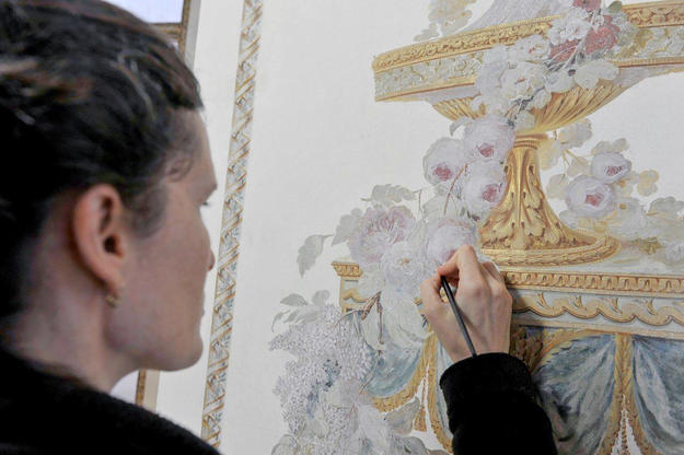 A conservator works on the interior paintings , 2012