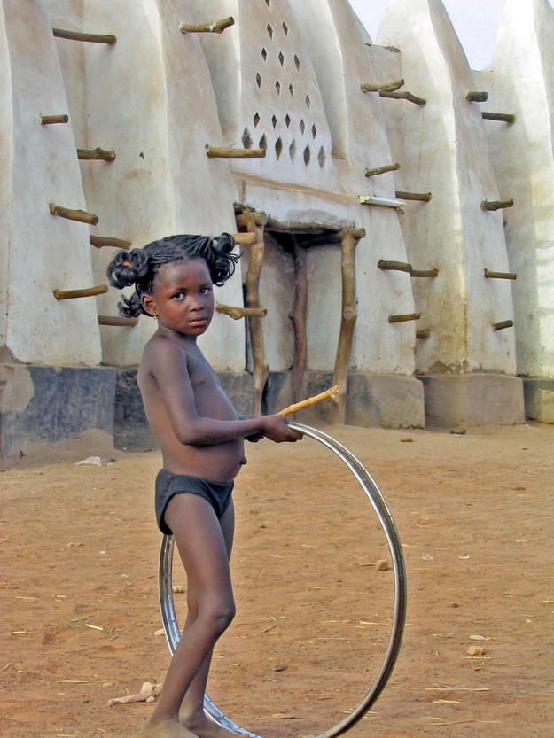A young villager plays outside the mosque, 2004