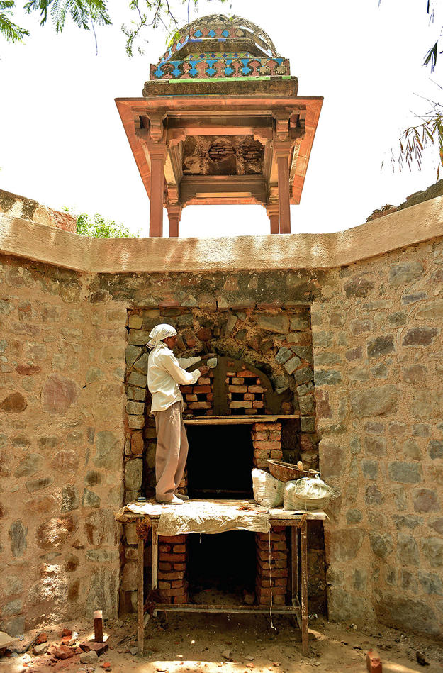 A conservator repairs the arched entrance to the chamber, 2014