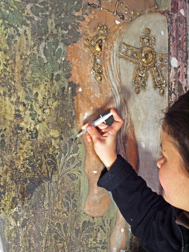 A conservator consolidating part of the fresco, 2012