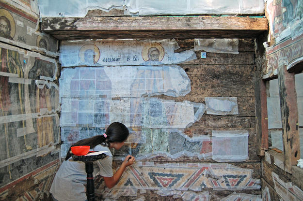 A conservator consolidates the exisiting painting at Ursi, 2013