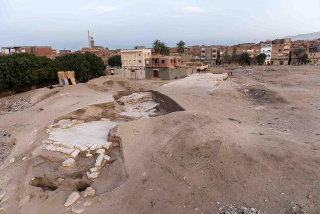 View of the excavated pylon of the Osiris Temple at Kom al-Sultan from north showing modern encroachment, 2018.