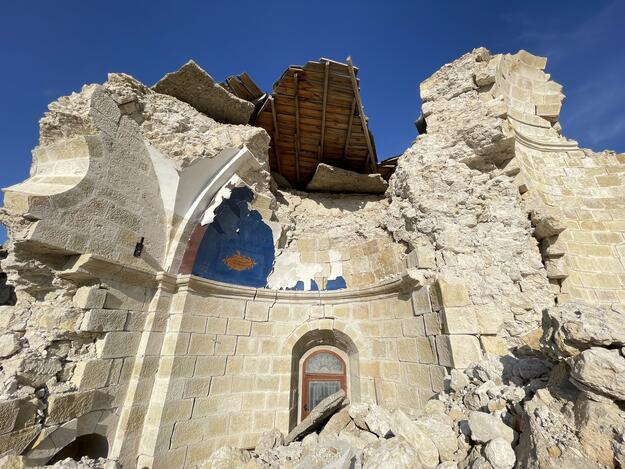 Partially collapsed white stone building with interior of dome painted blue