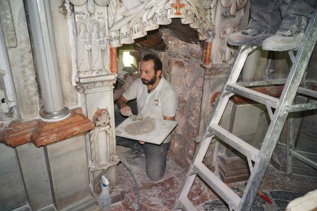 A mason carries out repairs in the interior masonry cladding, in the opening between the Chapel of the Angel and the Tomb Chamber, 2016