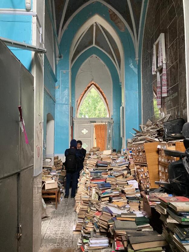 Piles of books on floor of damaged building