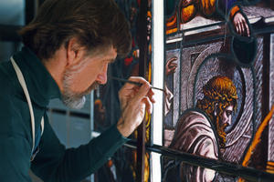 Craftsman Erik Erickson in-painting a restored glass insert to be discernable as a modern intervention only upon close examination., 1990