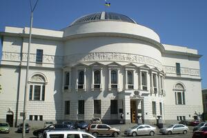 Large white building with glass dome and Ukrainian flag on top