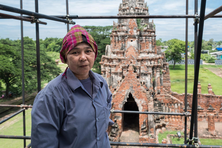 Conservator Khun Peng poses on scaffolding at Wat Chaiwatthanaram.