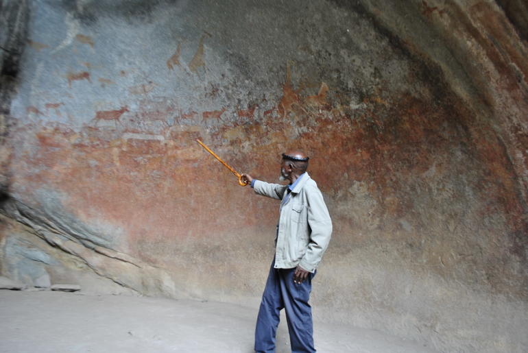 David Ngwenya, a local steward of Matobo Hills Cultural Landscape in Zimbabwe, stands in front of its endangered rock art.