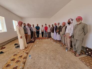 Ream (in pink) and the EOD team meeting with Eyzidi religious leaders at the nearby Community Hall during reconstruction of Mam Rashan Shrine, Iraq.